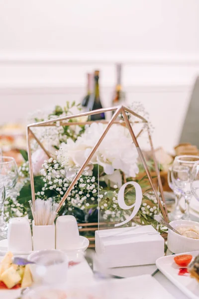 table number nine. wedding table. cured table. Round Banquet table served. Interior of restaurant for wedding dinner, ready for guests. Decorated with floral arrangement. wine glasses and napkins.