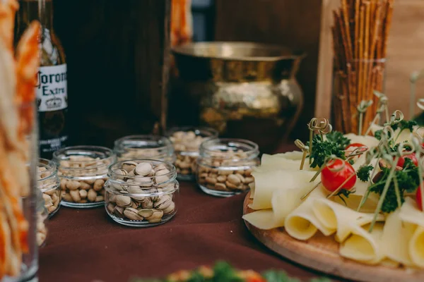 Slané ořechy na dřevěném stole na stole, svatební hostinu. pivní bar a svačinu. stravování v restauraci — Stock fotografie