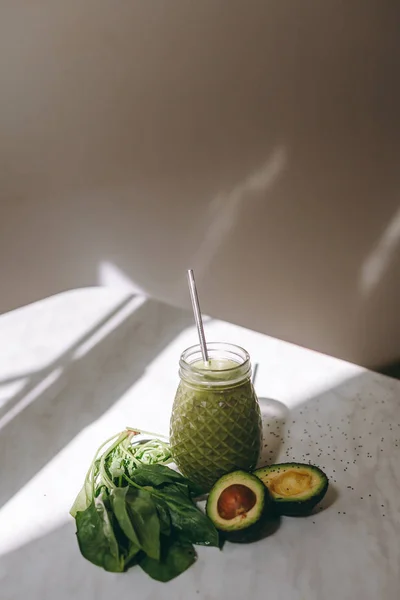 Organik ve sağlıklı yeşil smoothie muz, ıspanak, avokado, narenciye ve chia tohum üstünde a rustik arka plan withcopy yer cam şişelerde