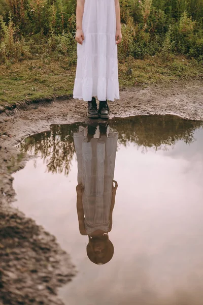 Spiegelbild eines schönen Mädchens in einem weißen Boho-Kleid im See — Stockfoto