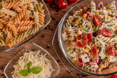 Lezzetli makarna salatası veya Akdeniz salatası. Domates mozzarella fesleğen Mısır baharat ve zeytinyağı ahşap bir masa üzerinde. Geleneksel İtalyan yemekleri