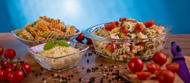 Lezzetli makarna salatası veya Akdeniz salatası. Mozzarella peyniri Fesleğenli domates baharat ve zeytinyağı ahşap bir masa üzerinde Mısır. Geleneksel İtalyan yemekleri - web banner tasarımı