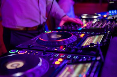 Müzikal etkinlikler için profesyonel ses mikseri. Eller arka plan renkli ışık atmosfer Dj operatörü