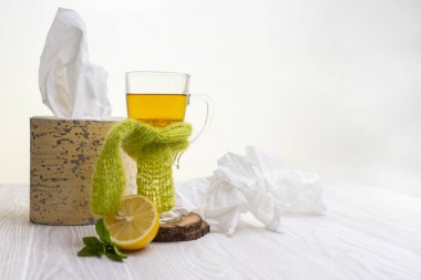 yeşil bir eşarp ve mendil ile yüksek bir cam kupa bitkisel limon çayı