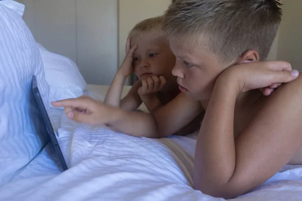 brothers play a computer game on a touch screen computer