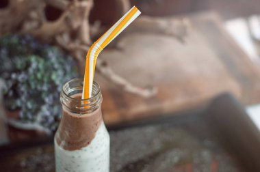 Çikolata muz smoothie eski ahşap rustik arka plan üzerinde bir cam kavanoza Chia pudingle. Sağlıklı vejetaryen kahvaltı yoğurt kefir chia tohum ile. Seçilen odak, yatay, kopyalama alanı