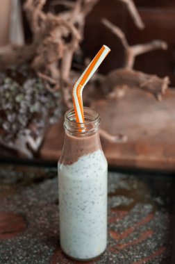 Çikolata muz smoothie eski ahşap rustik arka plan üzerinde bir cam kavanoza Chia pudingle. Sağlıklı vejetaryen kahvaltı yoğurt kefir chia tohum ile. Seçilen odak, dikey, kopyalama alanı