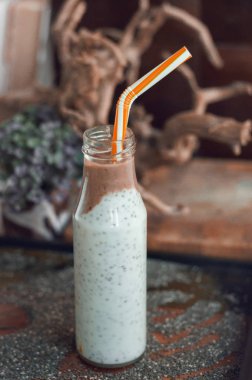 Çikolata muz smoothie eski ahşap rustik arka plan üzerinde bir cam kavanoza Chia pudingle. Sağlıklı vejetaryen kahvaltı yoğurt kefir chia tohum ile. Seçilen odak, dikey, kopyalama alanı