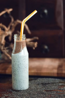 Çikolata muz smoothie eski ahşap rustik arka plan üzerinde bir cam kavanoza Chia pudingle. Sağlıklı vejetaryen kahvaltı yoğurt kefir chia tohum ile. Seçilen odak, dikey, kopyalama alanı