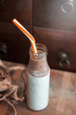 Çikolata muz smoothie eski ahşap rustik arka plan üzerinde bir cam kavanoza Chia pudingle. Sağlıklı vejetaryen kahvaltı yoğurt kefir chia tohum ile. Seçilen odak, dikey, kopyalama alanı