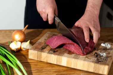 Erkek Şef domuz eti yemek pişirmek için hazırlanıyor. Pişirme biftek et dostum. Ahşap masa, üstten görünüm sığır eti yemek için ham maddeler. Kopya alanı ile beyaz backgroung.