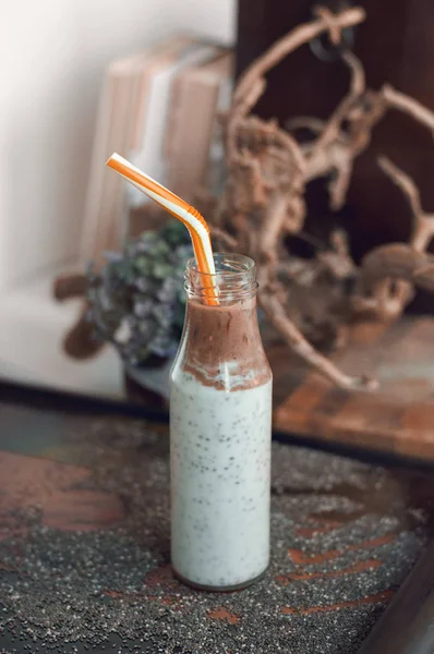 Çikolata muz smoothie eski ahşap rustik arka plan üzerinde bir cam kavanoza Chia pudingle. Sağlıklı vejetaryen kahvaltı yoğurt kefir chia tohum ile. Seçilen odak, dikey, kopyalama alanı