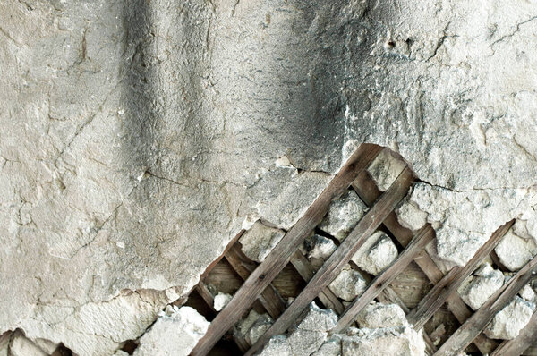 Сгорело и повреждено старое грязное деревянное и цементное покрытие стены разрушенного дома. Старые деревянные доски стены из глины, гранж фоновой текстуры
