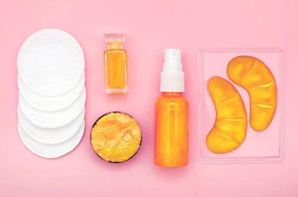 Flat lay composition with cosmetic products on pink background. Female self-care. Top view.