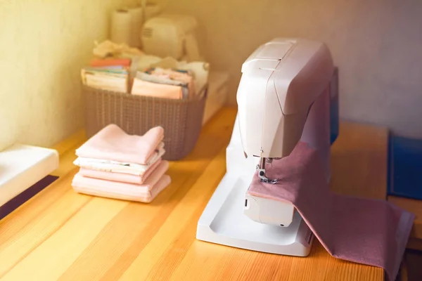 Closeup the sewing machine and item of clothing. Modern sewing machine on table in tailor\'s workshop