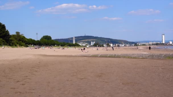 Mensen op Swansea zandstrand op een hete zonnige dag. — Stockvideo