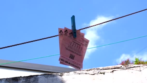 İngiliz piyango biletleri mavi gökyüzü arka planında bir çamaşır ipine kesilmiş.. — Stok video