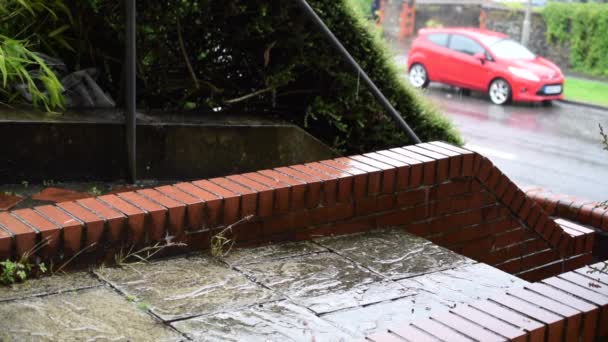 Σταγόνες βροχής πέφτουν στη σκάλα του σπιτιού και ένα κόκκινο αυτοκίνητο στο βάθος. — Αρχείο Βίντεο