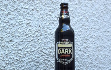 Beynin bira fabrikasından koyu bira şişesi açık dokulu arka planda.