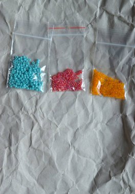 Gri dokuda renkli boncuklar.