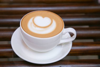 Cappucino kahve beyaz kalp şeklinde beyaz bir kupa