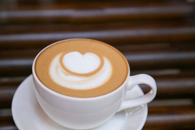 Cappucino kahve beyaz kalp şeklinde beyaz bir kupa