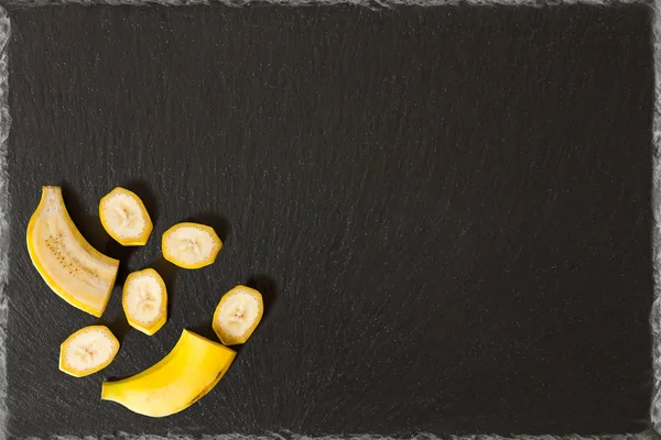 cut banana on a black slate background