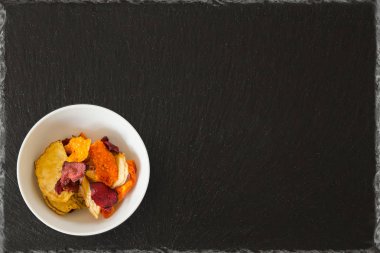 sebze cips havuç tatlı patates pancar patates kabak butternut sağlıklı snack siyah arduvaz arka plan ile yuvarlak kase