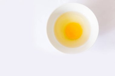  Beyaz bir arka plan ile kase çevresinde kırık yumurta