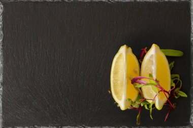 siyah bir arduvaz arka plan Bahçe Yeşil garnitür ile limon dilimli