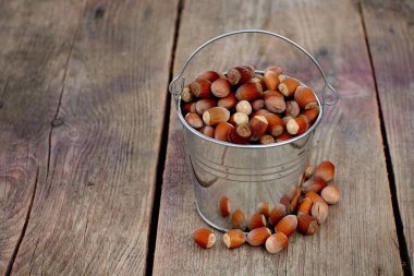 Bahçedeki ahşap arka planda bir kova dolusu fındık