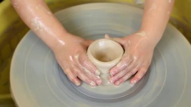 Çocukların elleri çömlekçi çarkında kil ürünleri üretmeyi öğrenir. Çömlek atölyesinde çocuklar için yüksek lisans. Sanat, zanaat