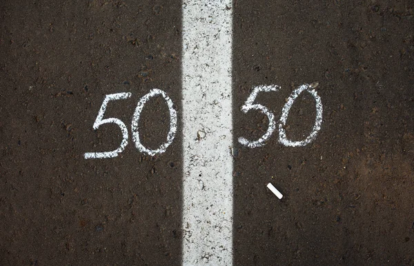 Symbol of gender equality 50/50 on asphalt