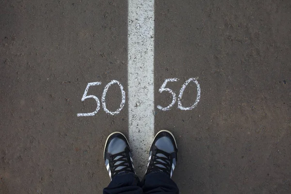 Symbol of gender equality 50/50 on asphalt, gender concept