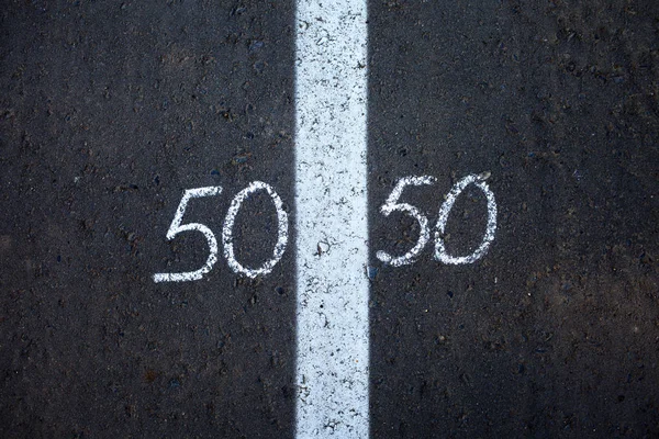 Symbol of gender equality 50/50 on asphalt