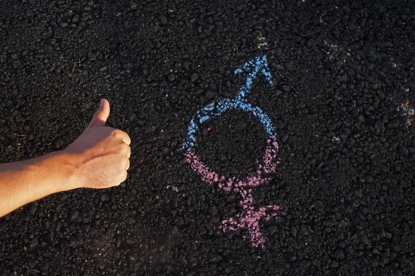 The hand with the symbol of gender equality on the pavement, the concept of gender. Man