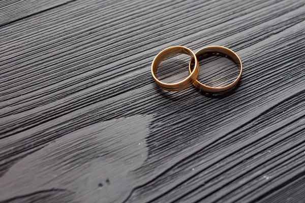 Wedding rings on the beautiful wooden surface texture. Beautiful black wooden background