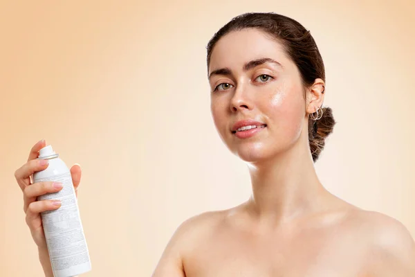 濡れた肌の若い白人女性は 熱水のボトルを保持します ベージュの背景 コピースペース スキンケア 保湿の概念 — ストック写真