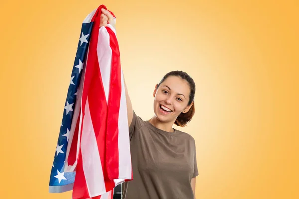 一个拿着美国国旗的白人快乐女人举起了国旗 黄色背景 爱国主义 自由和体育爱好者的概念 — 图库照片
