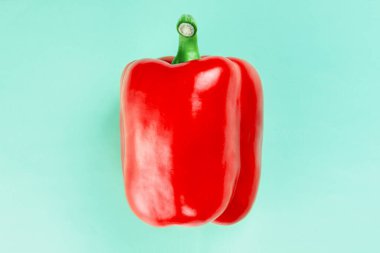 Turkuaz arka planda kırmızı biberli tatlı bir şekil. Uzayı kopyala Düz yatıyordu. Sağlıklı gıda ve diyet konsepti.