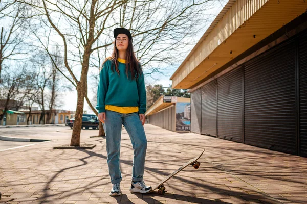 Ung Kaukasisk Hipsterkvinna Poserar Med Foten Skateboard Och Tittar Fjärran — Stockfoto