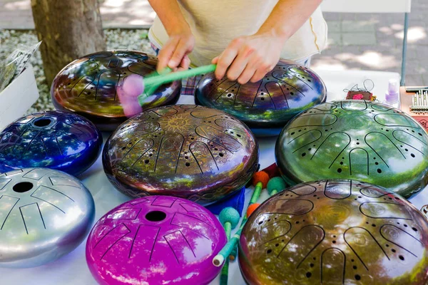 the musician plays colored hang drums, close-up.