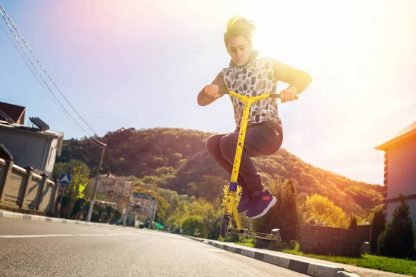 Ein Halbwüchsiger Junge Führt Einen Trick Auf Einem Motorroller Vor — Stockfoto