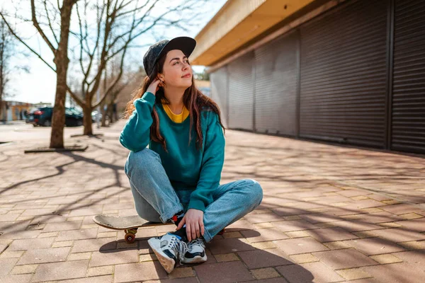 Mladá Krásná Běloška Sedí Skateboardu Dívá Jinam Pozadí Ulice Stromy — Stock fotografie