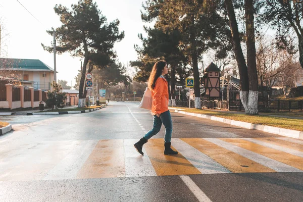 Una Mujer Con Una Chaqueta Naranja Caminando Sola Cruce Peatonal — Foto de Stock