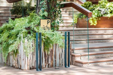 Binaların merdivenlerinin yanındaki bisiklet parkı için boş bir yer. Bisiklet resmi olan sarı bir tabela. Çevre dostu şehir taşımacılığı kavramı.