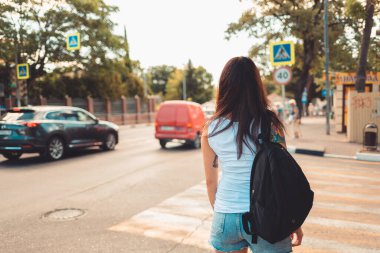 Yaz zamanı. Kolunda dövme olan bir kadın portresi yaya geçidinde duruyor. Dikiz aynası. Trafik ve güvenlik kuralları kavramı.