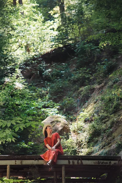 Eine Frau Rotem Kleid Und Hut Sitzt Mit Hängenden Beinen — Stockfoto