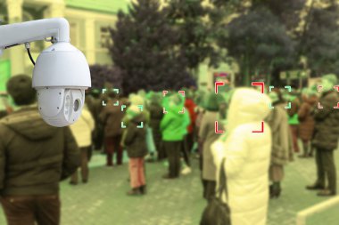 Güvenlik kamerası. Güvenlik kamerası halka açık yerlerde fotoğraf çekiyor. Arka plandaki insanlar kimlikleriyle bulanıklaşıyor. Modern teknoloji ve güvenlik kavramı.