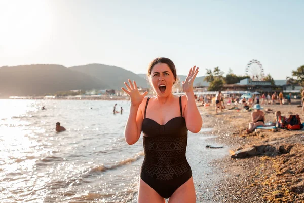 水着の女性が日焼けから悲鳴を上げる 顔と体の皮膚の赤み 背景には ビーチや海 保護とスキンケアの概念 — ストック写真
